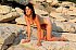 Female nudist on a rocky beach.